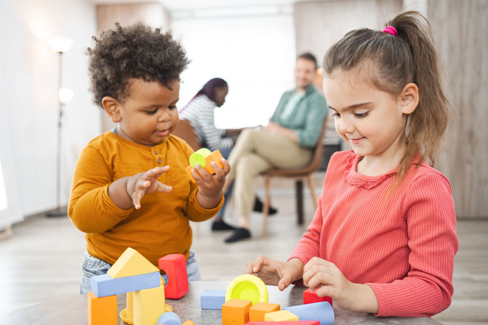 Niños pequeños jugando con bloques de colores