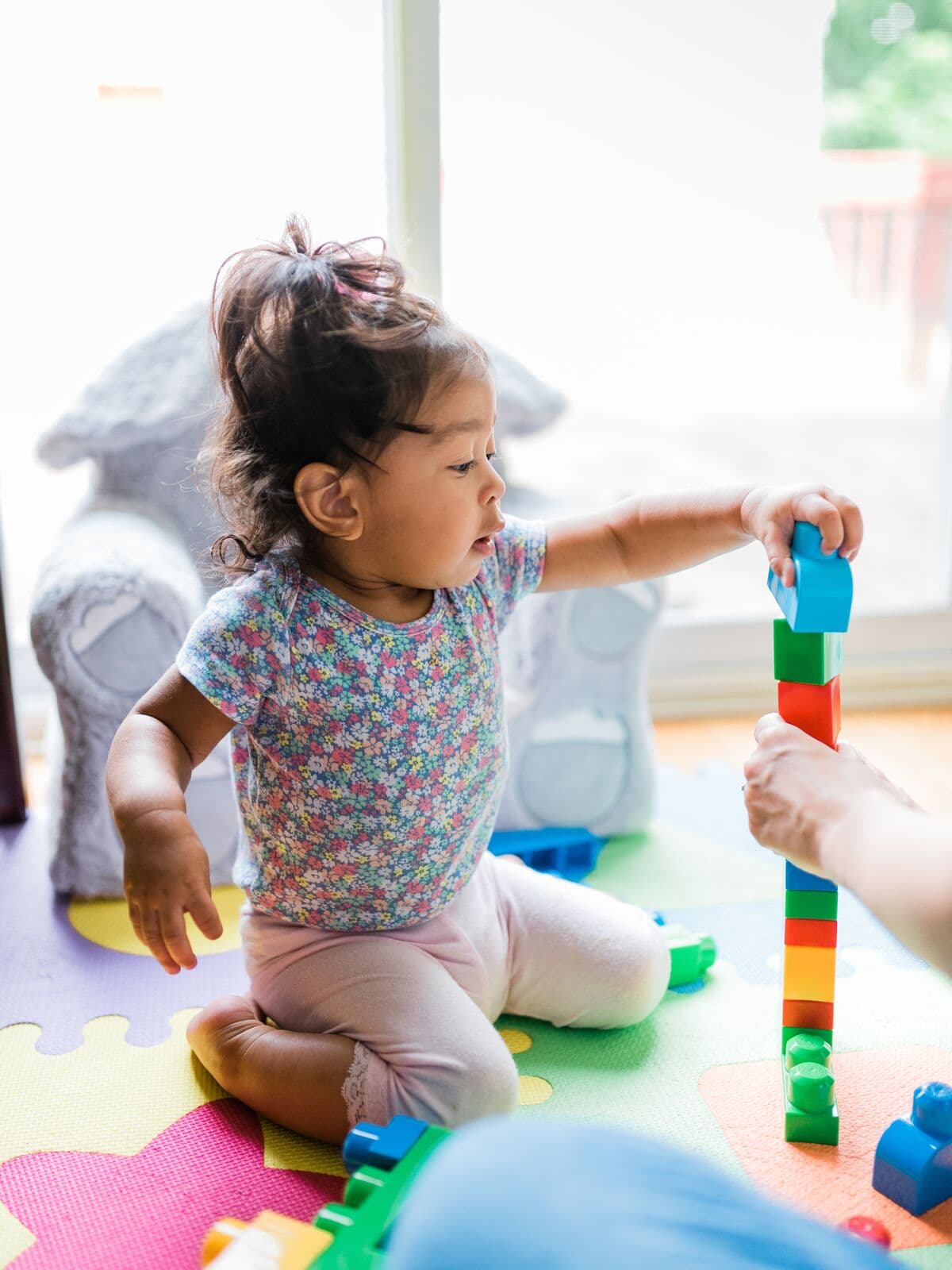 Una niña apilando bloques de colores
